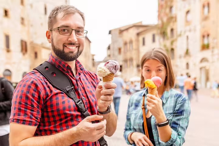 Tourists enjoy gelato in a charming Roman piazza, highlighting the cultural delights of a private Rome kickstart tour.