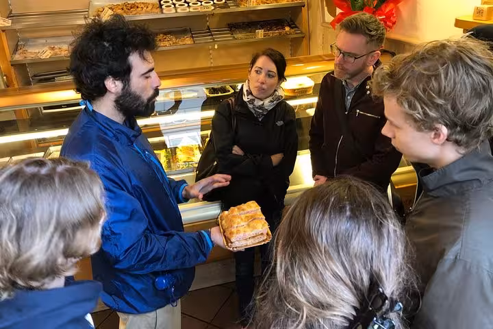 Tour participants engage in a pastry tasting session at a local bakery on the Rome Rione Parione food tour.