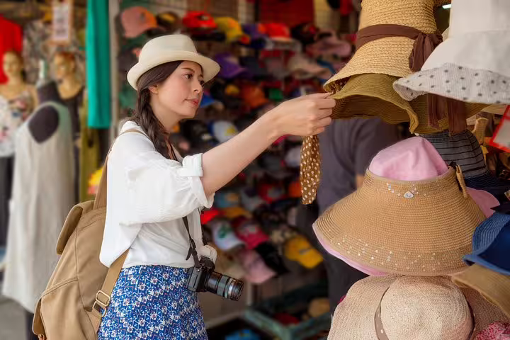 Traveler browsing stylish sun hats at a local Rome boutique during a half-day VIP shopping tour with personal shopper