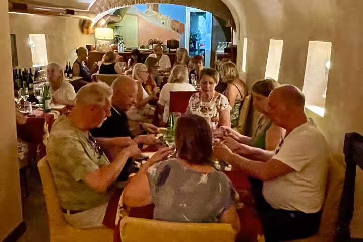 Small group enjoying a guided gourmet food and wine tasting in an intimate Trastevere restaurant in Rome