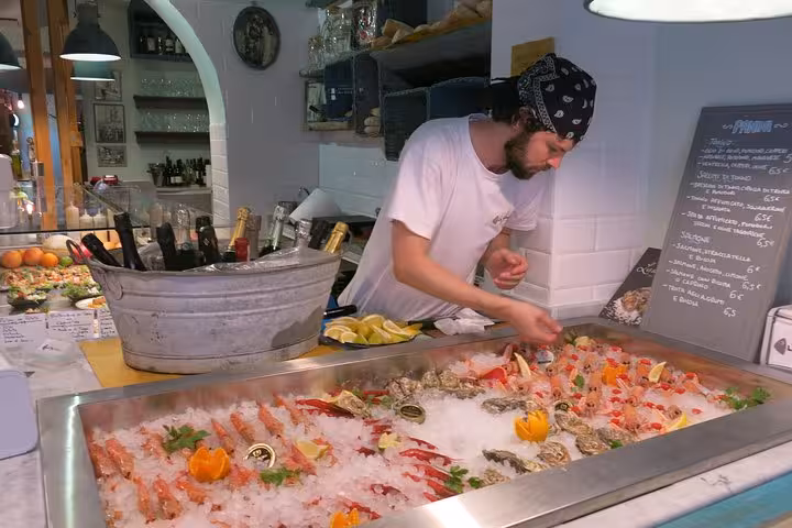 Savor fresh seafood at a vibrant market stop on the Rome Trastevere Walking Food Tour.