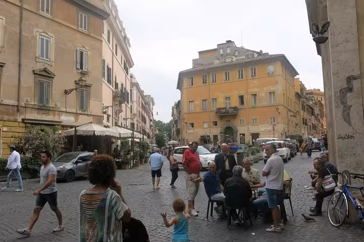 Bustling Trastevere square with locals and tourists enjoying an authentic Rome walking food tour experience.
