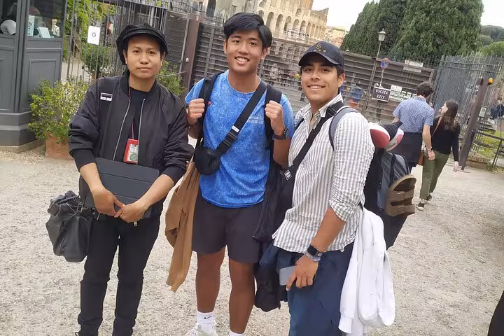 Three tourists ready for the Rome Underground Tour with the Colosseum in the background.