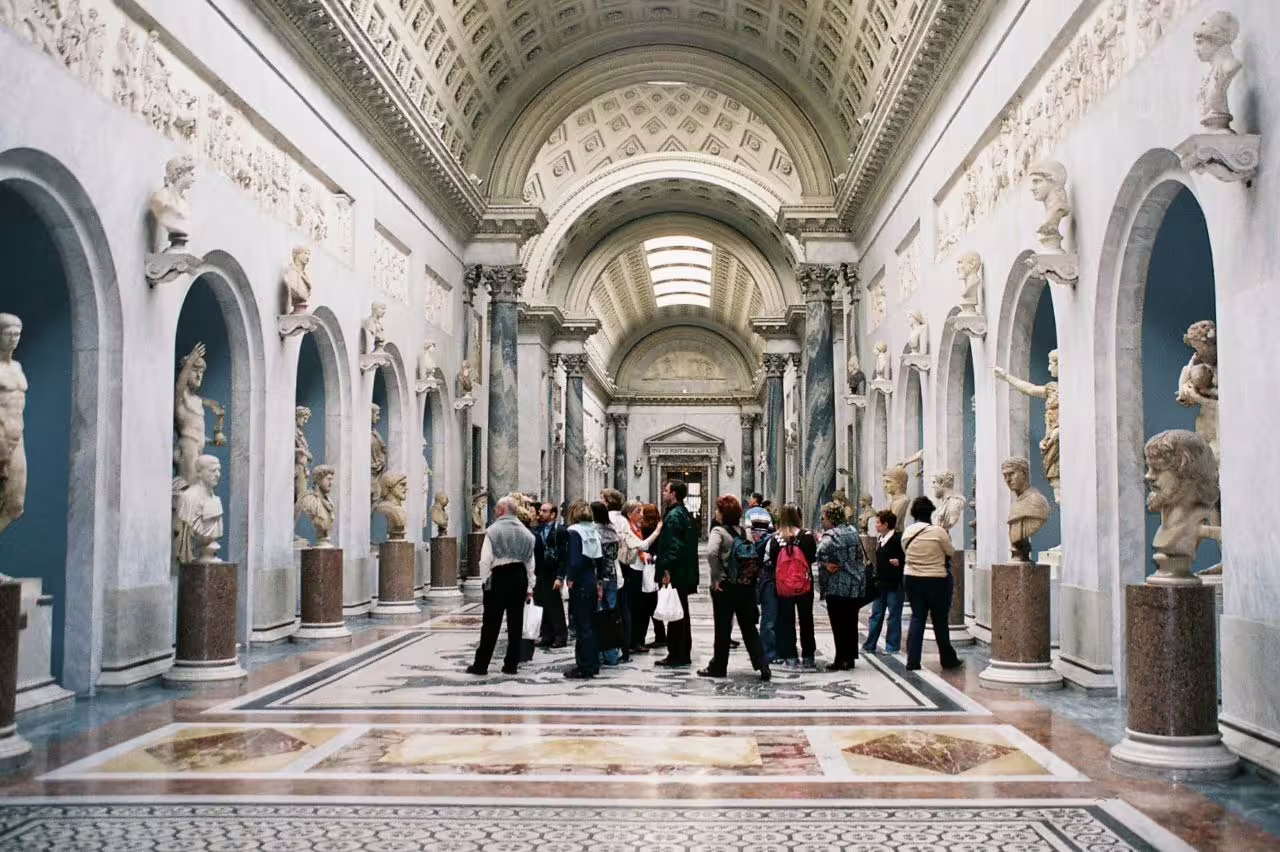 Visitors in Vatican Museums sculpture gallery, ideal stop on Rome sunset golf cart churches and food tour