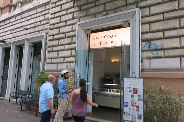Visitors enter Gelateria del Teatro in Rome, known for artisanal gelato, during a private vegetarian food tour.