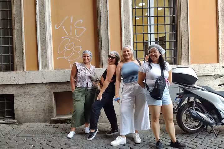 Group of tourists posing in Rome during Vespa guided tour, enjoying local sights and vibrant city atmosphere.