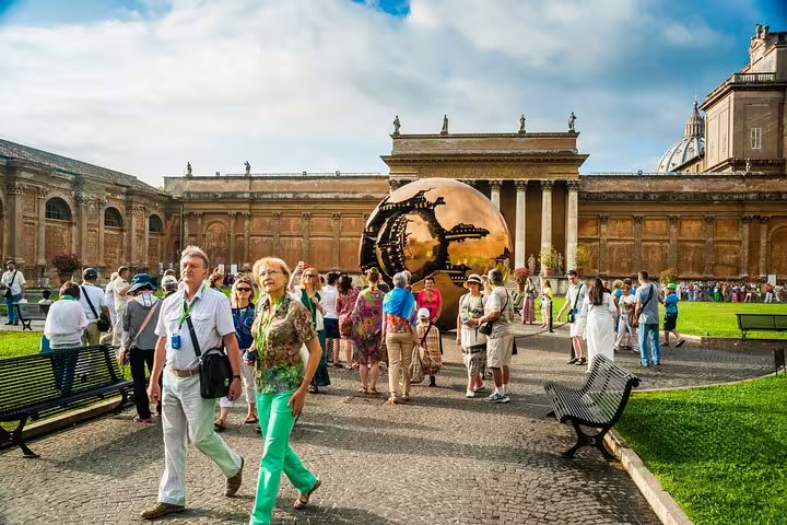 Small group on a Rome VIP tour exploring the Vatican Museums courtyard with the bronze Sphere Within Sphere sculpture in view