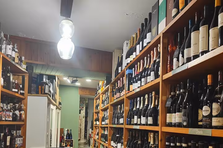 Cozy wine shop interior with shelves filled with a variety of wines, ideal for a sommelier course in Rome.