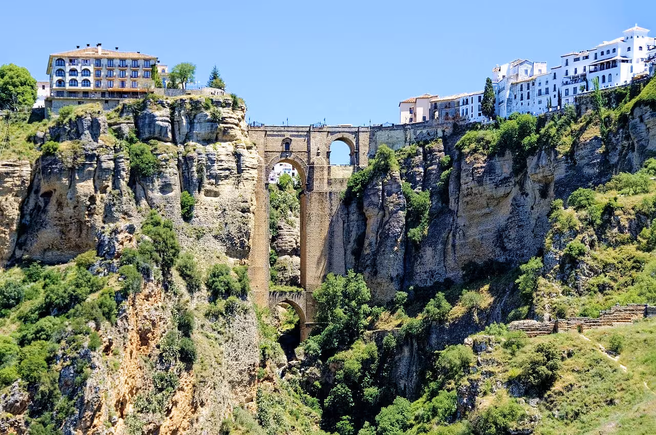 Stunning view of Ronda's Puente Nuevo bridge spanning dramatic cliffs under a clear blue sky.