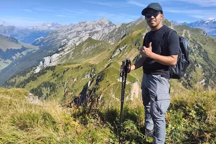 Hiker at Rophaien peak viewpoint on Zurich day trip above Lake Lucerne, Swiss Alps ridge panorama