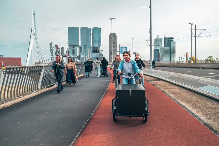 Cyclists crossing Erasmus Bridge on a Rotterdam highlights bike tour, with local guide and skyline views