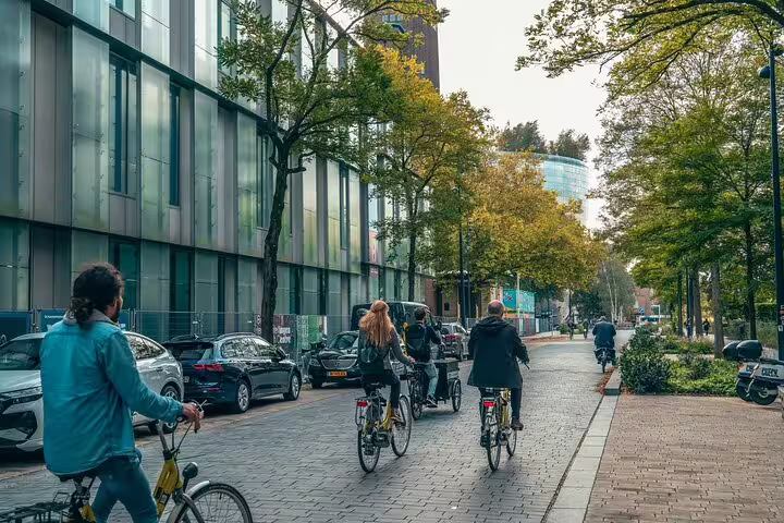 Group cycling through modern Rotterdam streets on a classic highlights bike tour with a local guide