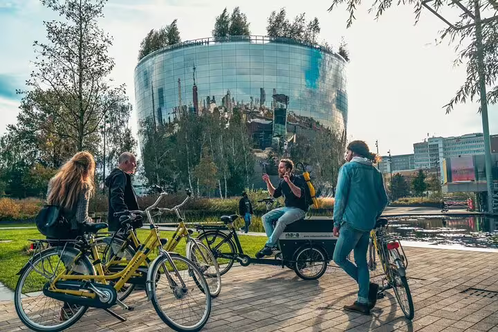 Local guide briefing cyclists by the mirrored Depot Boijmans Van Beuningen on a Rotterdam bike tour
