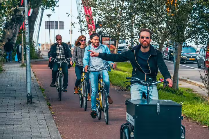 Local guide leading a small group ride on Rotterdam bike lanes during the classic highlights city tour