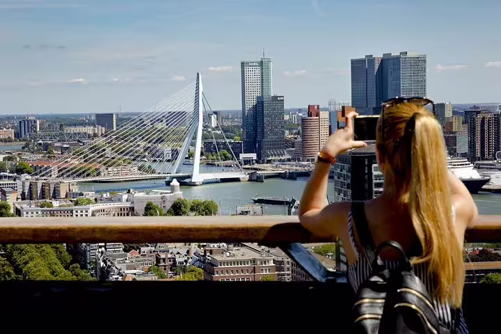 Traveler photographing Erasmus Bridge skyline on Rotterdam e-scavenger hunt tour, self-guided city discovery