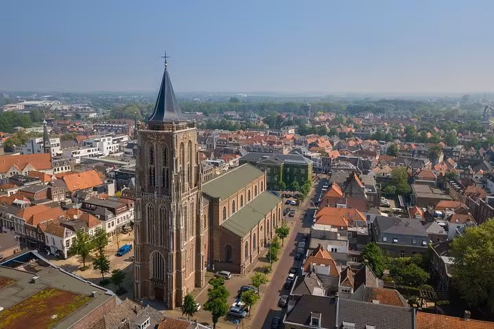 Aerial view of a historic Dutch church and rooftops on a private tour from Rotterdam to towns, mills and castles