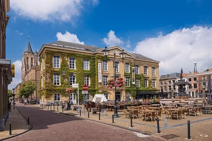 Charming Dutch town square with ivy-covered buildings and cafés on a private Rotterdam historic towns tour