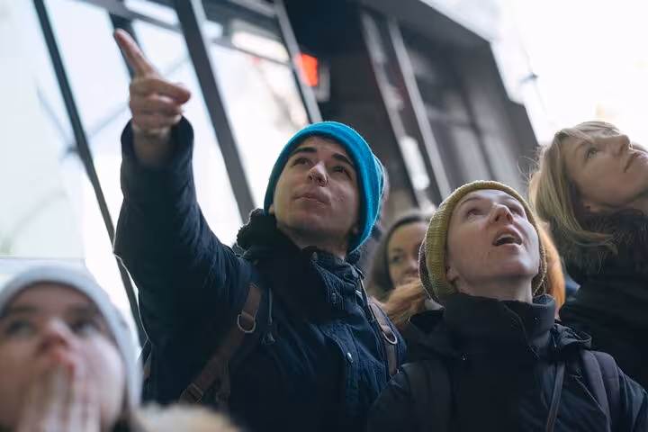 Private Rotterdam sightseeing tour guests look up as guide points out modern architecture inside a landmark building