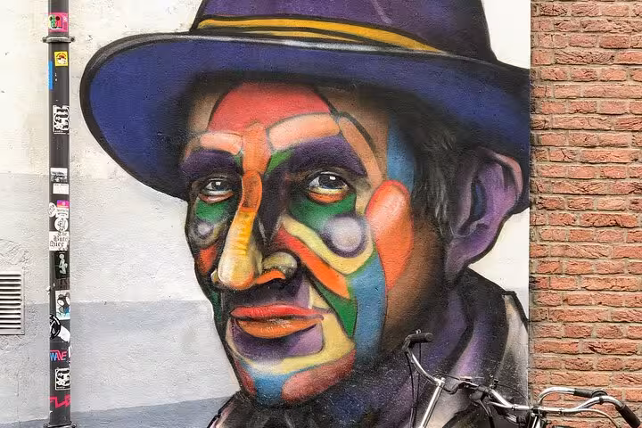 Colorful street art portrait mural in Rotterdam with bicycle, seen on Your Own Holland private city tour