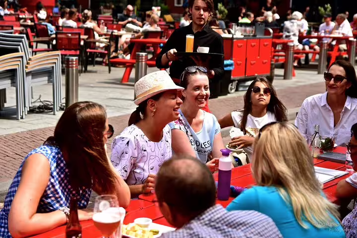 Tour group relaxing at outdoor cafe after Rotterdam street art private walking tour in the vibrant city center