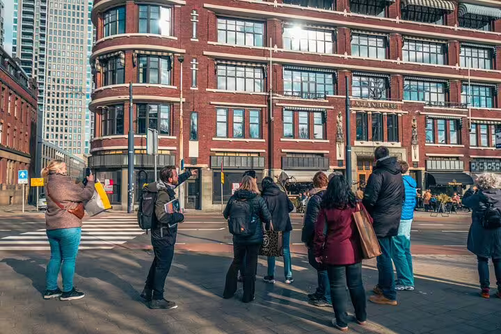 Dutch local guide leads small group past historic red-brick building on Rotterdam highlights walking tour
