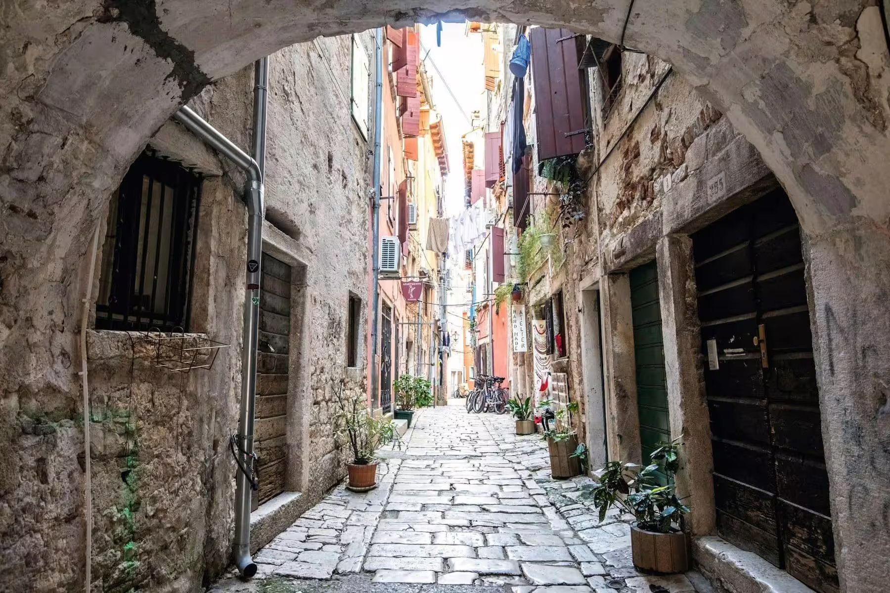 Stone archway alley in Rovinj old town, a walking break on the Istrian Coast boat cruise with BBQ from Poreč