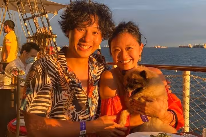 Couple with their dog basking in the sunset glow on the Royal Albatross, highlighting a memorable cruise experience.
