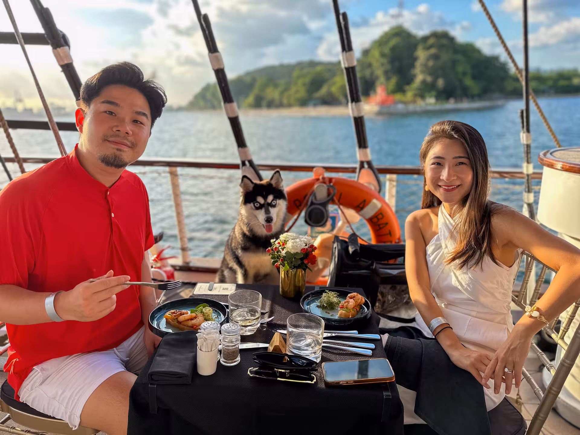 A family with their dog enjoying a moment on the Royal Albatross deck, holding a bouquet, capturing cruise memories.