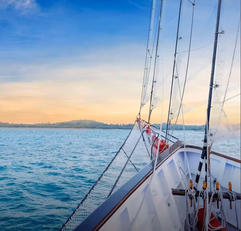 Serene view from the bow of the Royal Albatross during a sunset cruise, with clear skies and tranquil waters.