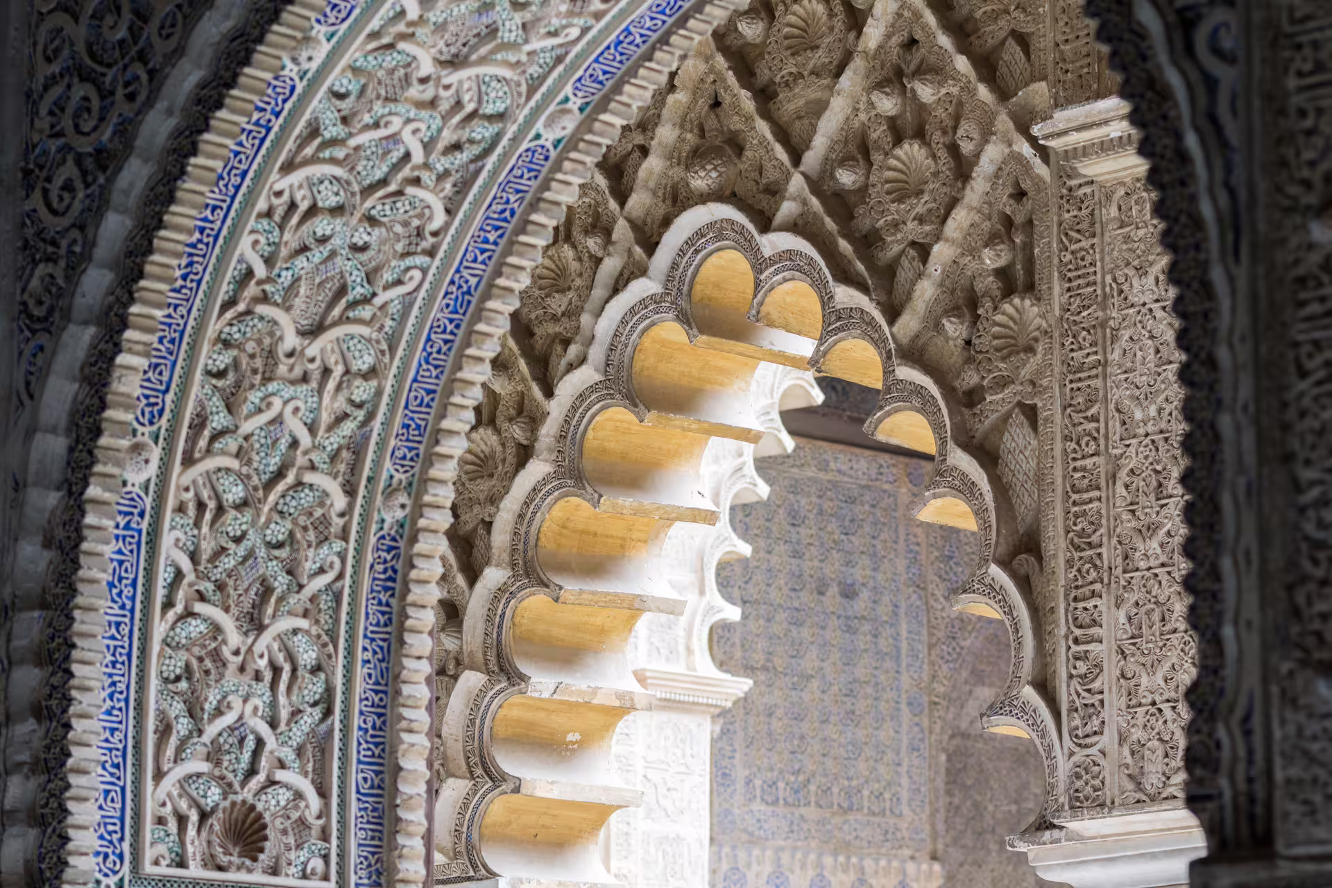 Intricate Moorish arch design in the Royal Alcazar of Seville, showcasing detailed carvings and vibrant tilework on a private tour.