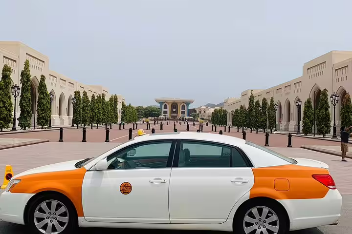 A taxi is parked in front of the Royal Opera House Muscat, showcasing stunning architectural design.