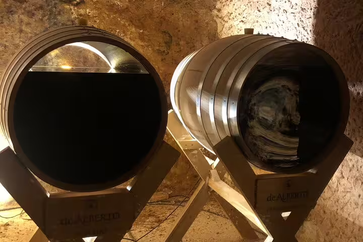 Two wooden wine barrels inside a rustic Rueda cellar, highlighting the Madrid wine tour's authentic experience.