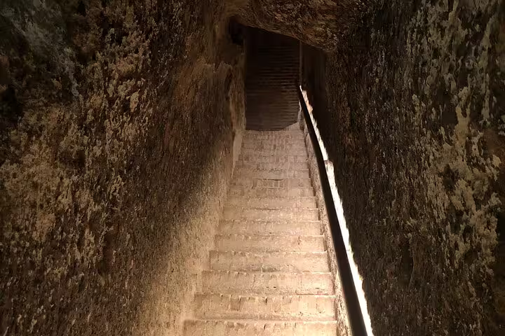 Descend stone stairs into a historic wine cellar on the Rueda White Wine Tour with Michelin-star lunch from Madrid.