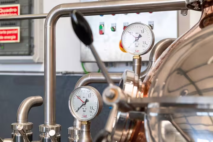 Close-up of a rum distillery's machinery with pressure gauges, highlighting the craftsmanship in the Sunny Southwest tour.