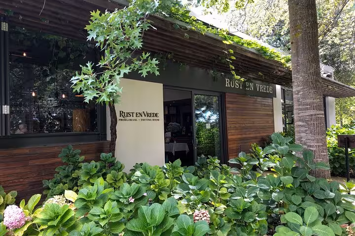 Entrance to the Rust en Vrede wine estate surrounded by greenery, featured on the Stellenbosch VIP Wine Tour.