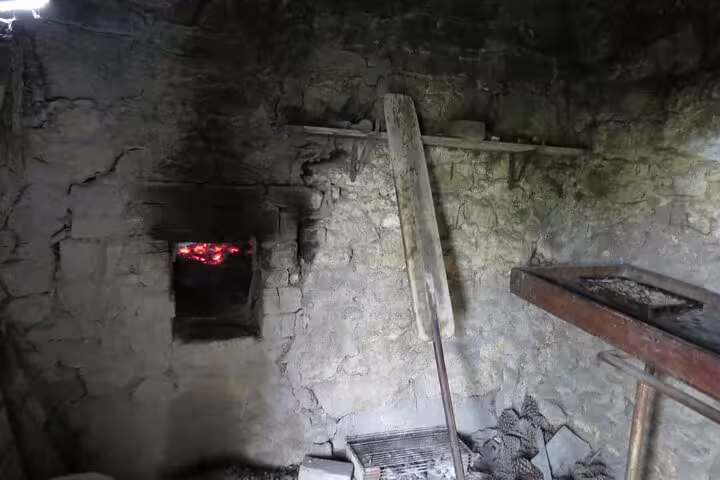Rustic stone oven with glowing embers, ideal for authentic bread baking in a traditional setting.