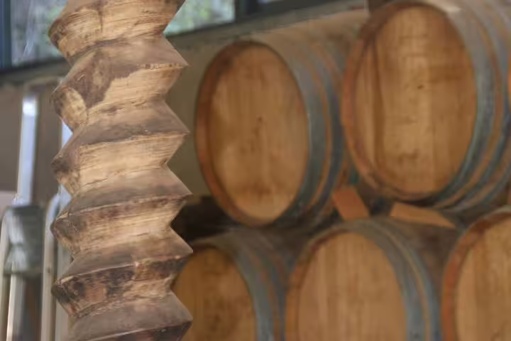 Rustic wine barrels in a cellar, highlighting the authentic vineyard experience of our bestselling wine tour and 4x4 adventure.
