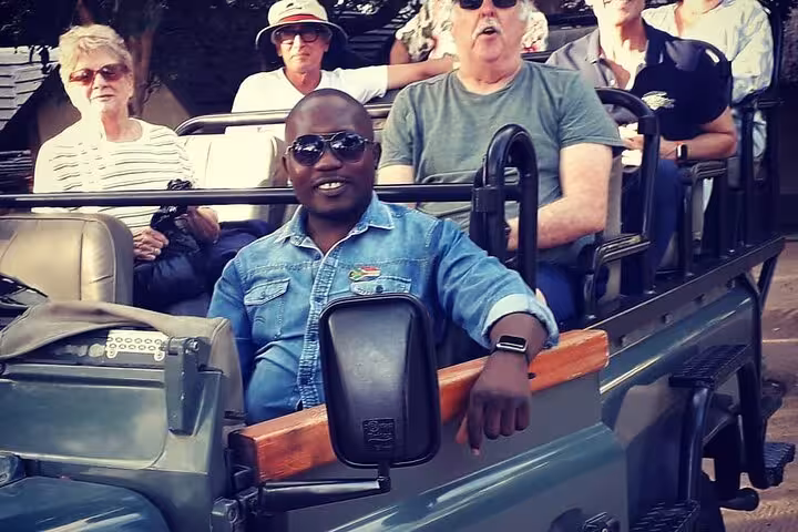 Tourists enjoy a thrilling open-air jeep ride during the Sabi Sands Sunset Safari, capturing the essence of adventure.