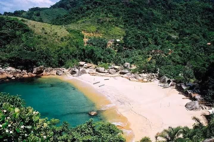 Aerial view of secluded beach and lush greenery on the Saco Bravo Waterfall adventure tour by Paraty Tours.