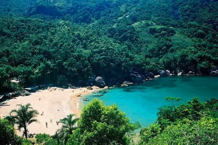 Scenic view of a secluded beach and turquoise waters surrounded by lush greenery on the Saco Bravo adventure tour.