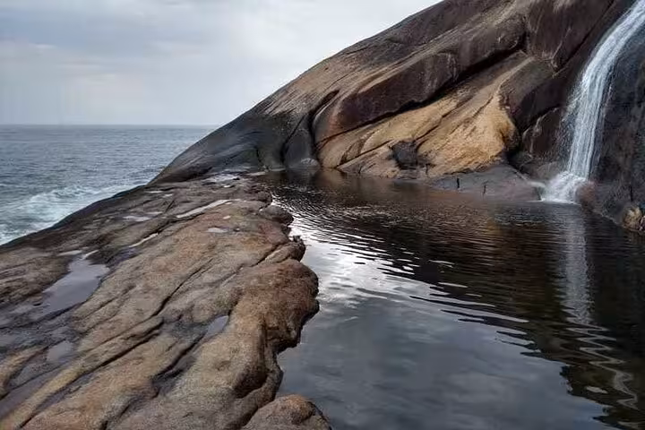Stunning view of Saco Bravo Waterfall cascading into a serene natural pool with ocean backdrop, perfect for Paraty adventure tours.