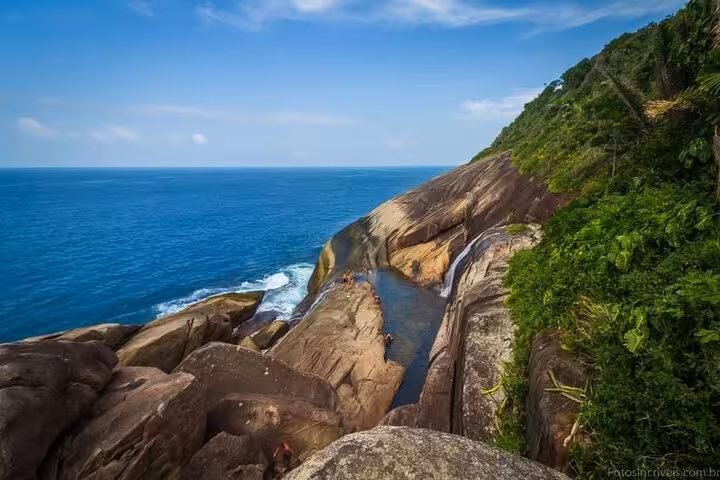 Breathtaking coastal view of Saco Bravo Waterfall merging into the ocean, surrounded by lush greenery, ideal for Paraty excursions.
