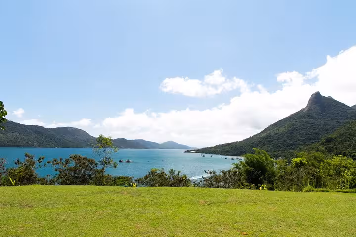 Scenic view of lush green landscape and tranquil waters at Saco Mamanguá Fjord, perfect for a half-day beach tour.