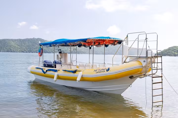 Empty tour boat moored at the serene Saco Mamanguá Fjord, ready for a half-day beach excursion.