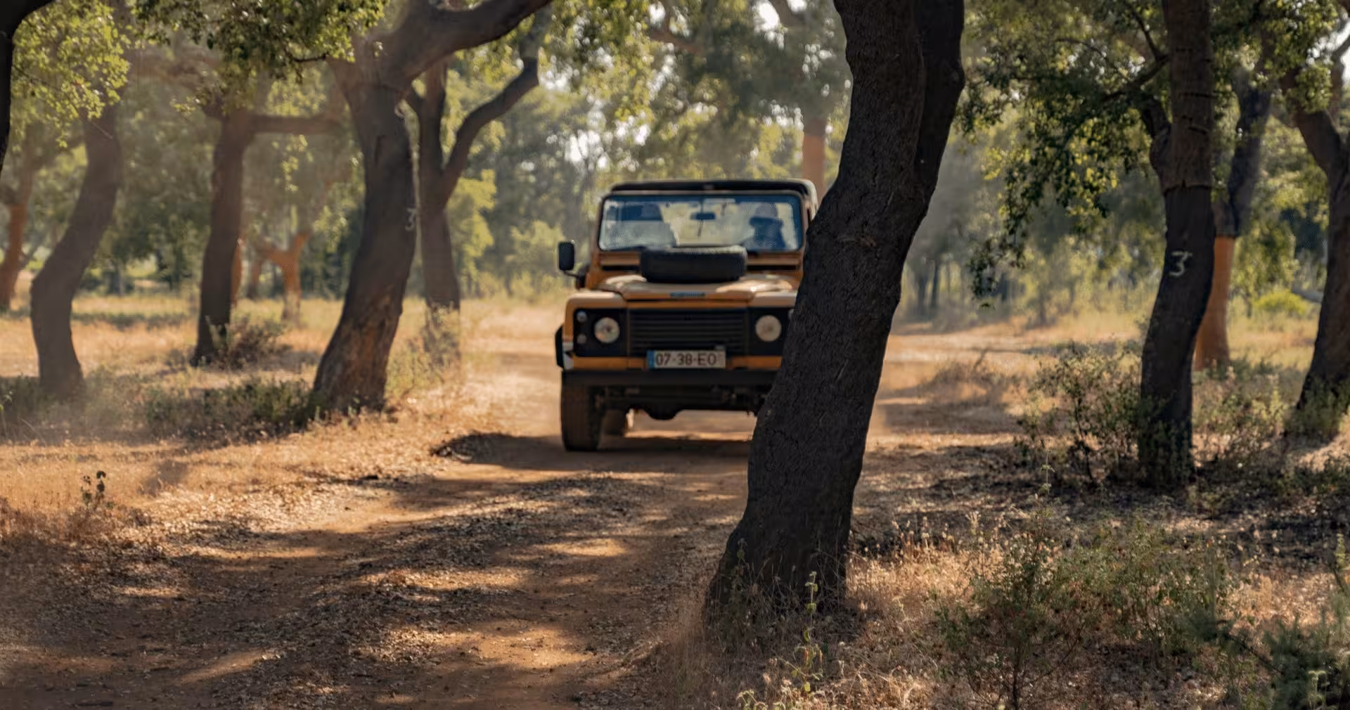 Safari jeep driving along a dusty forest track on a guided half-day private Algarve off-road adventure tour