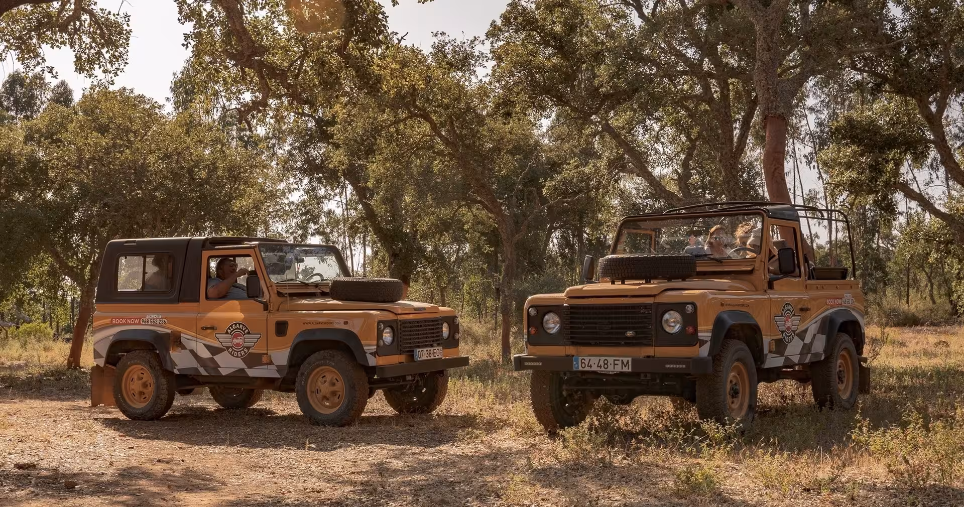 Two open-top safari jeeps parked under cork oak trees, ready for a half-day private Algarve off-road wildlife tour