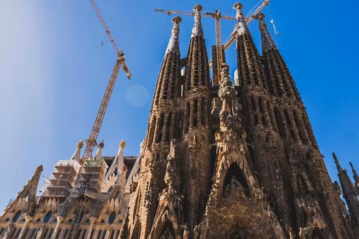 Stunning view of Sagrada Familia's intricate facade under blue skies, ideal for a private full day Barcelona tour.