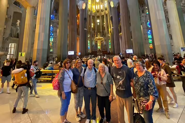 Group of tourists inside Sagrada Familia, Barcelona, marveling at the stunning stained glass and architecture.