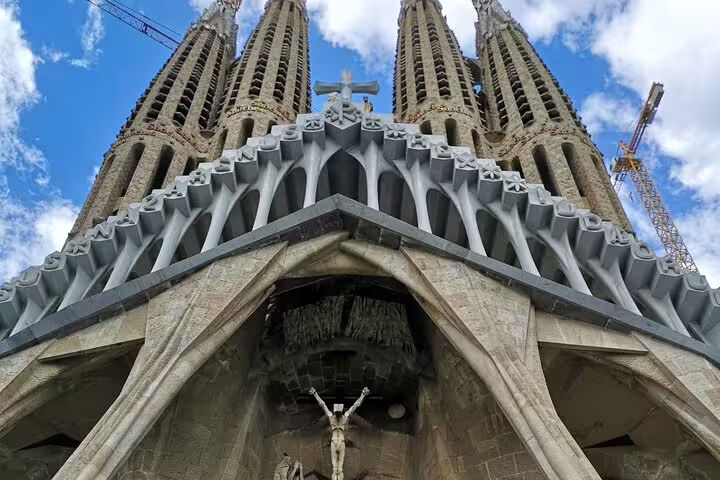 Majestic view of the Sagrada Familia's intricate facade under a blue sky, featured in our skip-the-line food and drink tour.