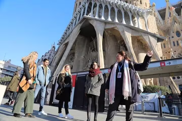 Guided small group listening outside Sagrada Familia entrance in Barcelona, starting an insider tour with skip-the-line access